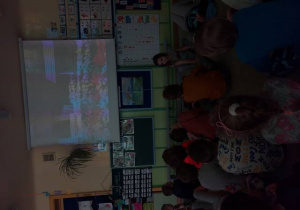 Dzieci oglądają film edukacyjny dotyczący dawnych zwyczajów witania wiosny
